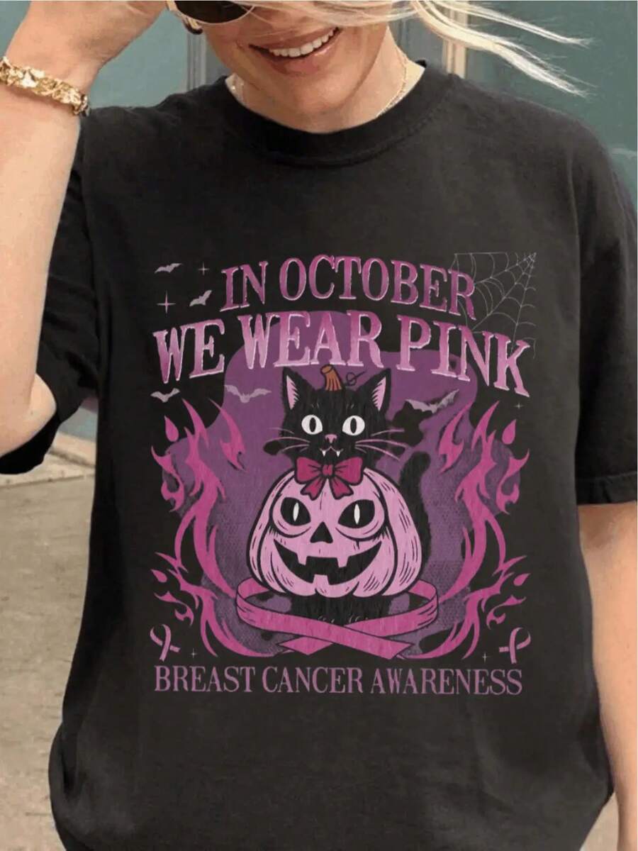 Women's Breast Cancer Awareness T-Shirt- Black With Pink Ribbon And "In October We Wear Pink" Slogan, Short Sleeve Round Neck Casual Top, Designed With Pink Cat And Pumpkin Lantern